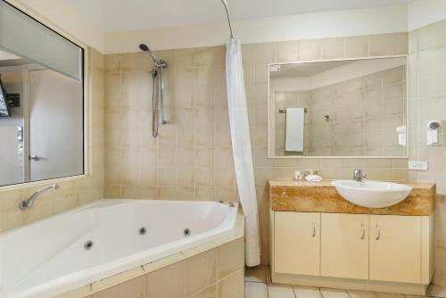 穆卢拉巴穆卢拉巴莱佛士酒店的带浴缸、水槽和镜子的浴室