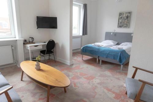 纳克斯考Hotel Harmonien的客房设有一张床、一张桌子和一张桌子。