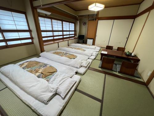 奈良Ryokan Kosen Kazeya Group的窗户房间里一排床