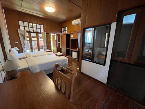 拉迈乌托邦度假村酒店的一间卧室配有一张床、一张桌子和一台电视。