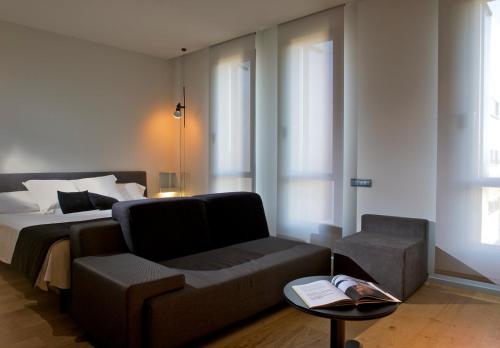 阿尔曼萨Blu Hotel Almansa的一间卧室配有一张床、一张沙发和一把椅子