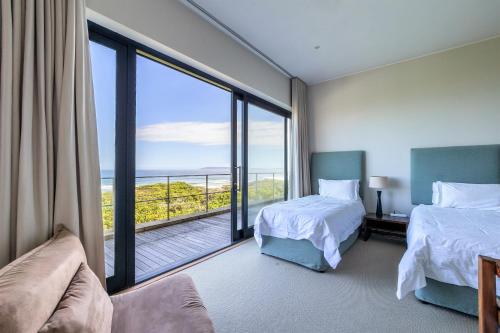普利登堡湾Whaleshaven 14的酒店客房设有两张床和大窗户。