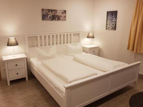 罗滕堡Hocher Hotel的一张带2个床头柜和2盏灯的白色床