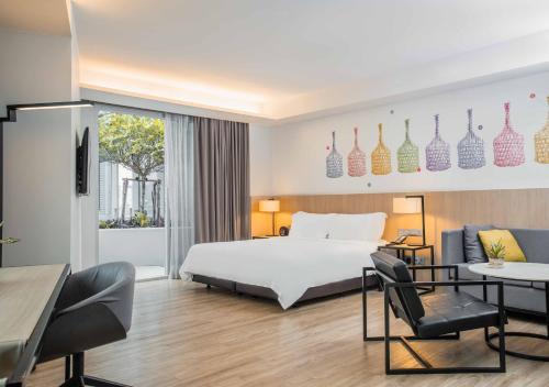 曼谷曼谷名致酒店式服务公寓的酒店客房带一张床、一张桌子和椅子