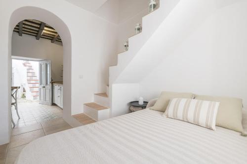 贝赫尔-德拉弗龙特拉Casa Manuela的白色卧室设有大床和楼梯