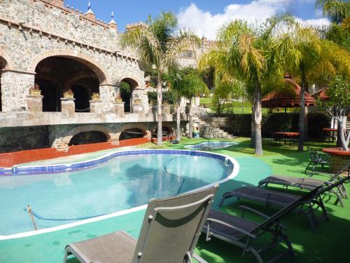 瓜纳华托卡斯提罗桑塔赛斯利亚酒店的一座带椅子的建筑前的游泳池
