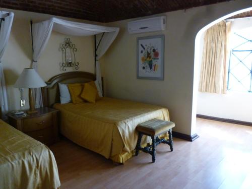 瓜纳华托卡斯提罗桑塔赛斯利亚酒店的卧室配有床、椅子和窗户。