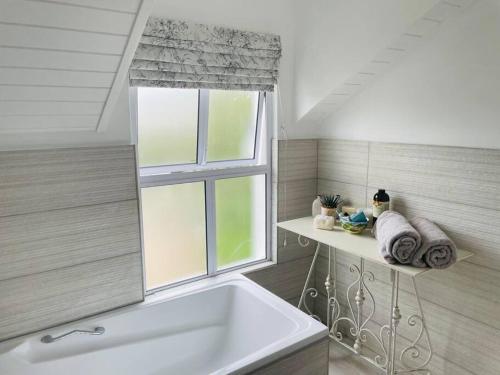 诺丁汉路Quaint Gowrie Village Apartment的带浴缸的浴室和窗户。
