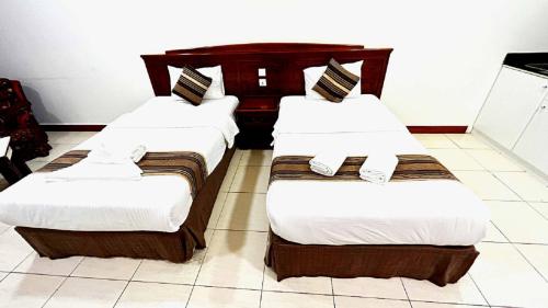 迪拜Moon Valley Hotel Apartment - Bur Dubai, Burjuman的白色和棕色的酒店客房内的两张床