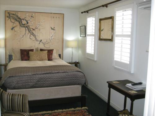 奥尔巴尼三个烟囱住宿加早餐旅馆的卧室配有床、桌子和窗户。