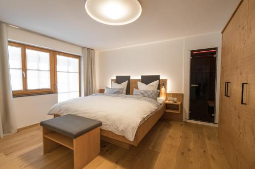 奥伯斯特多夫Landhaus Wiederkehr的一间卧室配有一张大床、凳子和电视