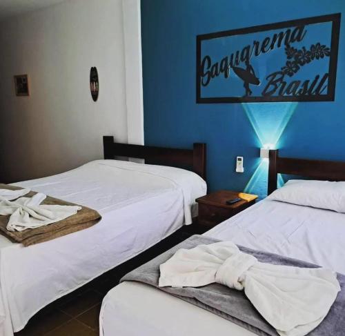 萨夸雷马POUSADA ARKAN BEACH的一间设有两张床和蓝色墙壁的客房