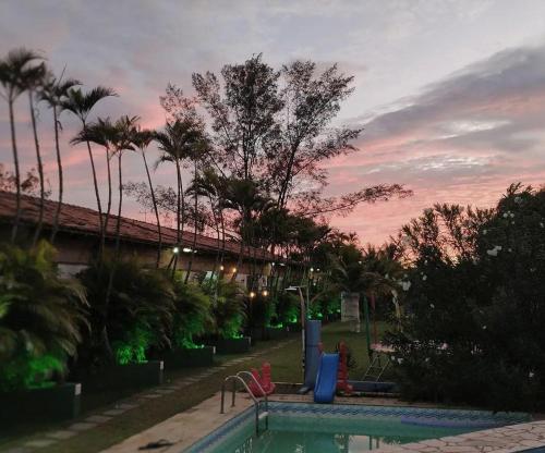 萨夸雷马POUSADA ARKAN BEACH的一个带游乐场和棕榈树的游泳池