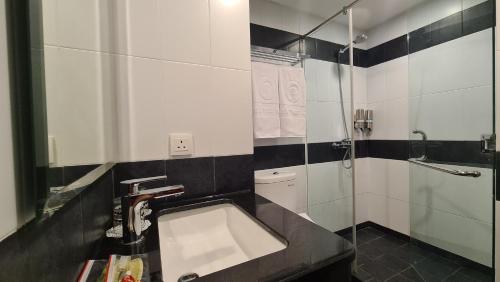 拉古洼d'primahotel Lagoi Bintan的一间带水槽和淋浴的浴室