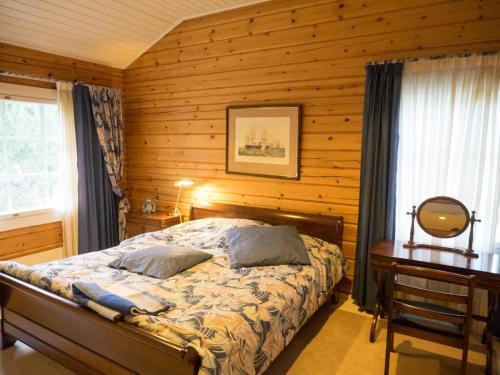 埃克奈斯Villa Mustikka的一间卧室设有一张床和木墙