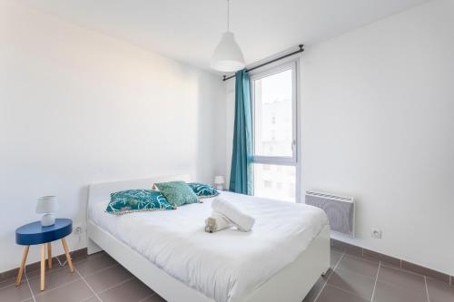马赛NEW JOLIETTE Comfortable Apartment well located with private parking的窗户客房内的一张白色床