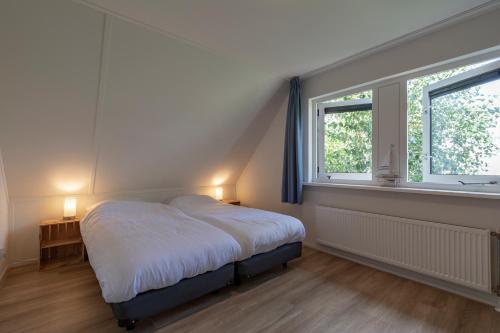 朱丽安娜多普Villa Duynopgangh 16 Julianadorp aan Zee的一间卧室设有一张床和一个窗口