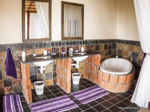 普拉伊拉多比莱尼Nghunghwa Lodge的浴室配有两个盥洗盆和浴缸。
