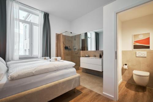科隆Park Avenue Apartments - Dom mit Stil - Küche - Parkplatz - WLAN - 65 Zoll TV - NETFLIX的一间带大床的卧室和一间浴室