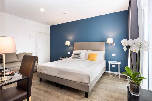 利尼亚诺萨比亚多罗Hotel Aurora的一间卧室设有一张床和蓝色的墙壁
