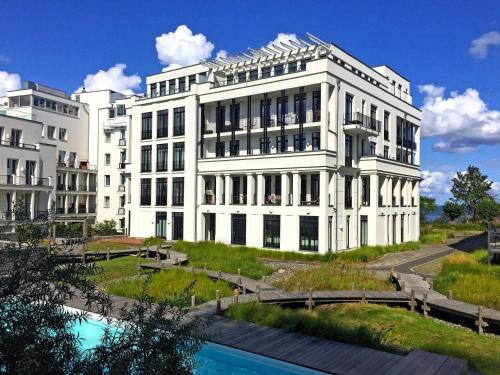 奥斯赛拜-塞林Villa Philine - Penthouse 28 mit Panoramablick, Pool, SPA & Kamin的一座白色的建筑,前面有一个游泳池