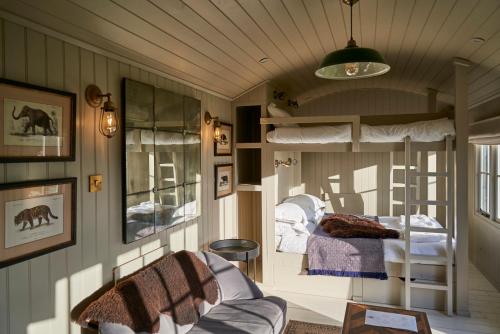 海斯Hog Deer Creek - At Port Lympne Reserve的客房设有两张双层床和一张沙发。