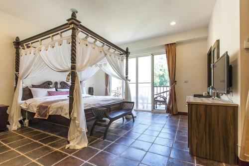 南庄乡幸福绿光峇里岛渡假会馆的一间卧室设有一张天蓬床和一个阳台