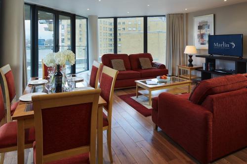伦敦Marlin Canary Wharf的一间带红色椅子的客厅和一间餐厅