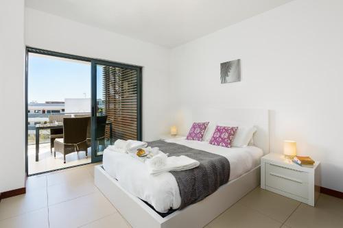 拉戈斯Marina Village Apartment的一间白色卧室,配有床和阳台