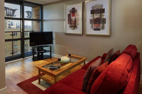 伦敦Marlin Canary Wharf的客厅配有红色沙发和茶几