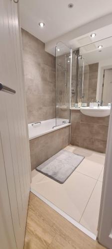 格洛斯特Luxury 1 Bedroom Waterside Apartment in Gloucester Docks的带淋浴、浴缸和盥洗盆的浴室