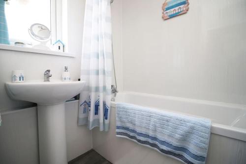 纽波特3 Bedroom family home Newport, Located next to M4的白色的浴室设有水槽、浴缸和水槽。