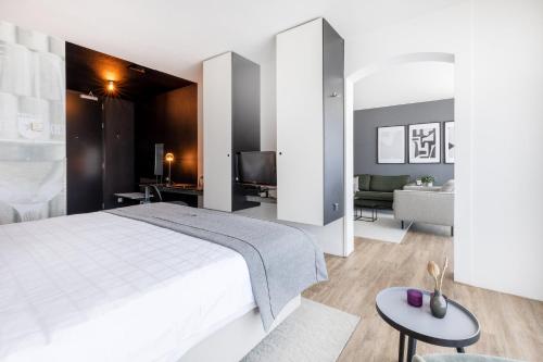 马斯特里赫特Select Hotel Maastricht的一间带白色床的卧室和一间客厅