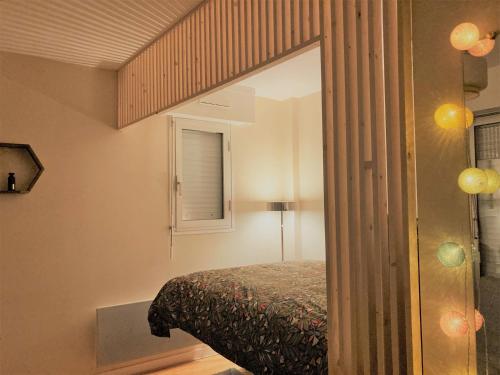 多维尔Studio proche plage balcon et parking的一间卧室配有一张床和镜子