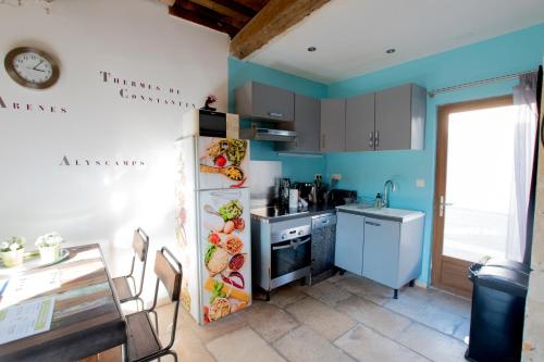 阿尔勒Ateliers, Terrasse - Parking - Clim的厨房设有蓝色的墙壁、桌子和水槽