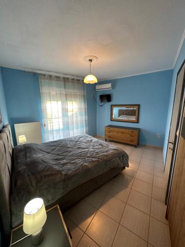 萨索斯Rania House的一间卧室设有一张大床和蓝色的墙壁