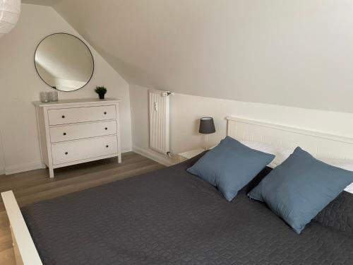 拉博埃Wohnungen mit direktem Meerblick的一间卧室配有一张带蓝色枕头和镜子的床