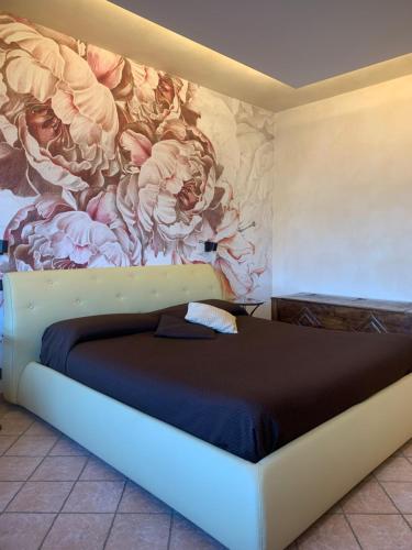 苏尔扎诺Pernice 77的卧室配有一张大床,墙上挂有绘画作品
