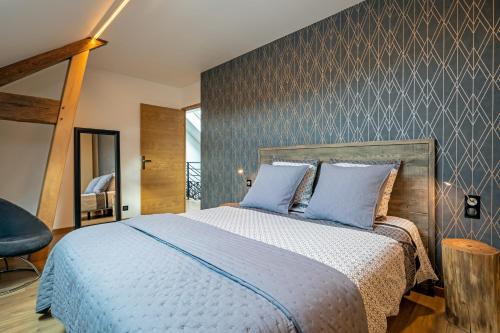 Criquebeuf-sur-SeineGîte Serenida的一间卧室配有一张带蓝色枕头的大床