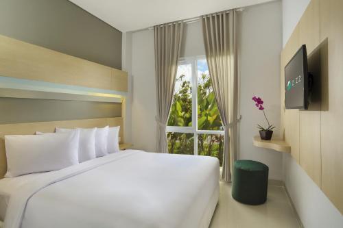 登巴萨吉兹会议酒店的卧室设有一张白色大床和一扇窗户。