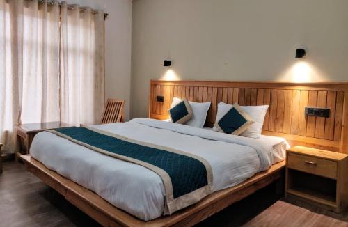 列城Gyalsaa Inn的一间卧室配有一张大床和木制床头板