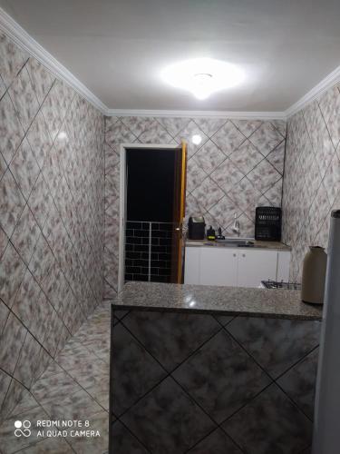 维索萨-杜塞阿拉Apartamento no centro de Vicosa-ce的一间厨房,在一间铺有瓷砖的房间里,配有柜台
