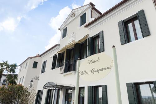 多洛加斯帕里尼别墅酒店的白色建筑,上面标有阅读全球豪华公寓的标志
