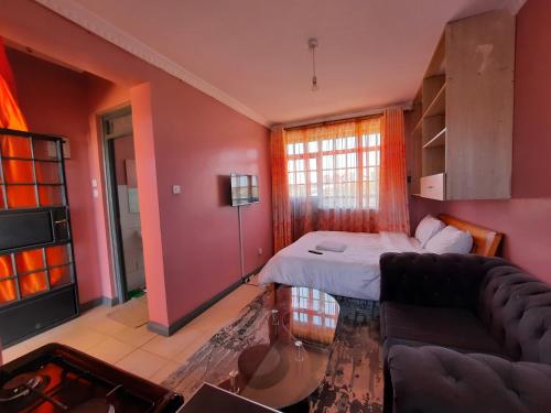 KikuyuPine Residency w Secure Parking, Wifi, Netflix & Rooftop Views的客厅配有床和沙发