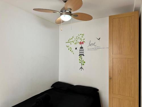 马德里Apartamento en Santiago Bernabéu的一间卧室配有吊扇和带花卉壁画的墙壁。