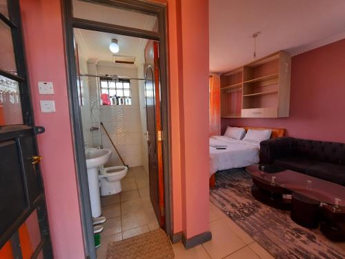 KikuyuPine Residency w Secure Parking, Wifi, Netflix & Rooftop Views的客房设有带一张床的卧室和一间浴室。