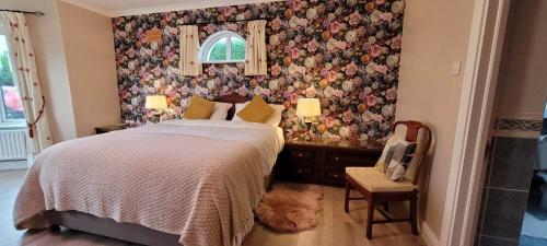BallybrittasThe Yoke的一间卧室配有一张带花卉壁纸的床