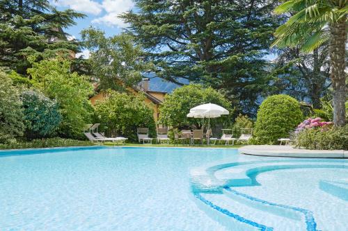 梅拉诺桑恩豪夫酒店的庭院内的游泳池,带椅子和树木