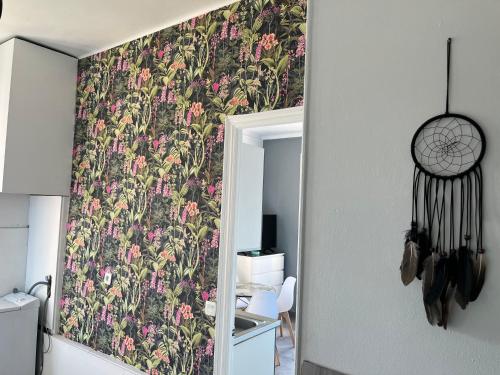 勒卡内Appartement PALOMA Proche Cannes的一间设有花卉壁纸的墙壁客房