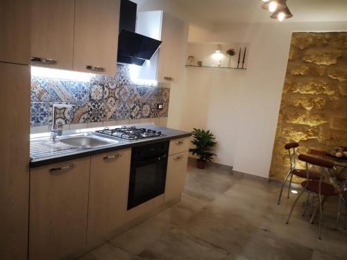阿格里真托La Perla della Cattedrale luxury home的厨房配有水槽和炉灶 顶部烤箱